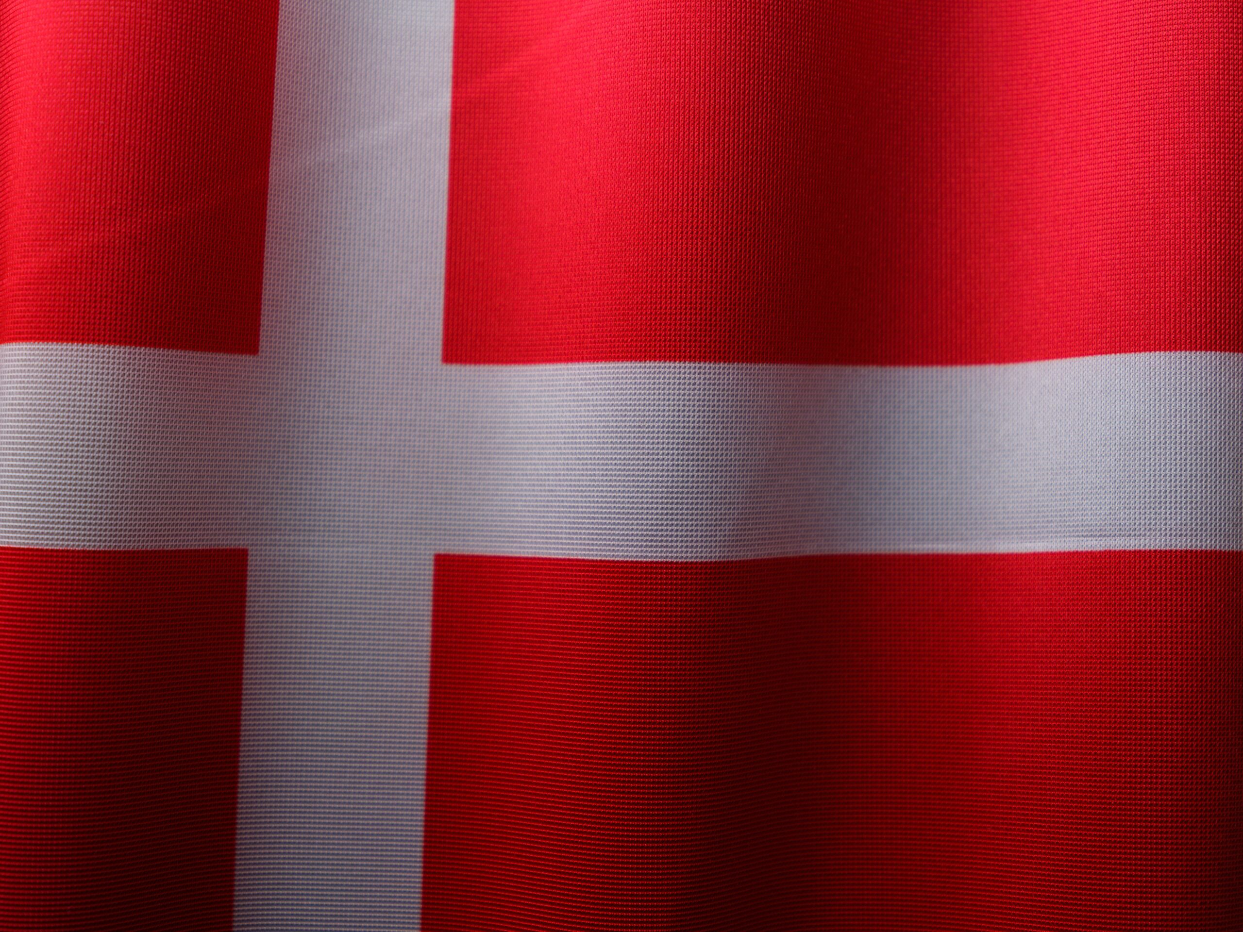 A detailed close-up of the vibrant red and white Danish flag, emphasizing patriotism and national pride.